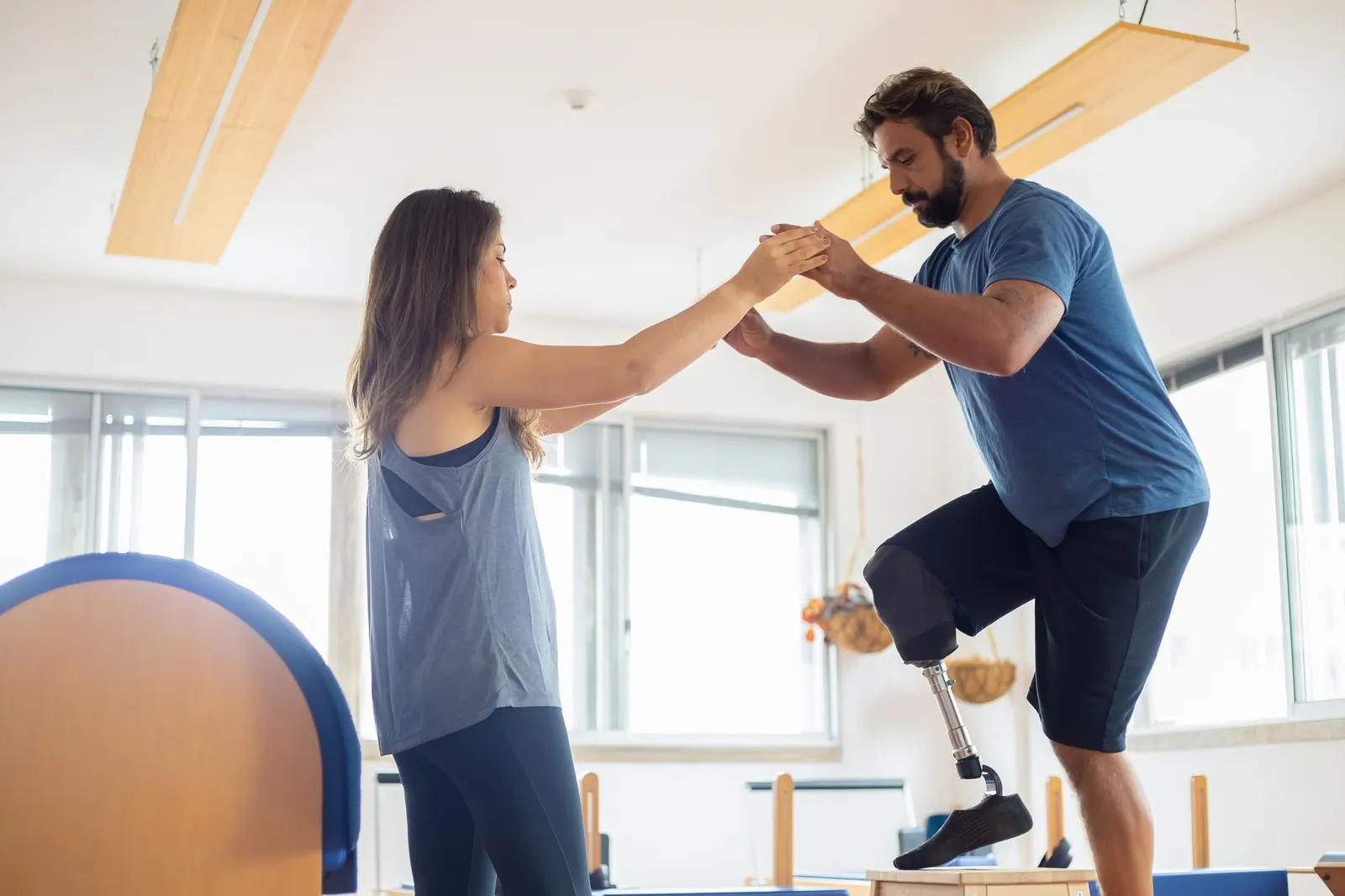 Therapist holding a patient's hands during single-leg balance training